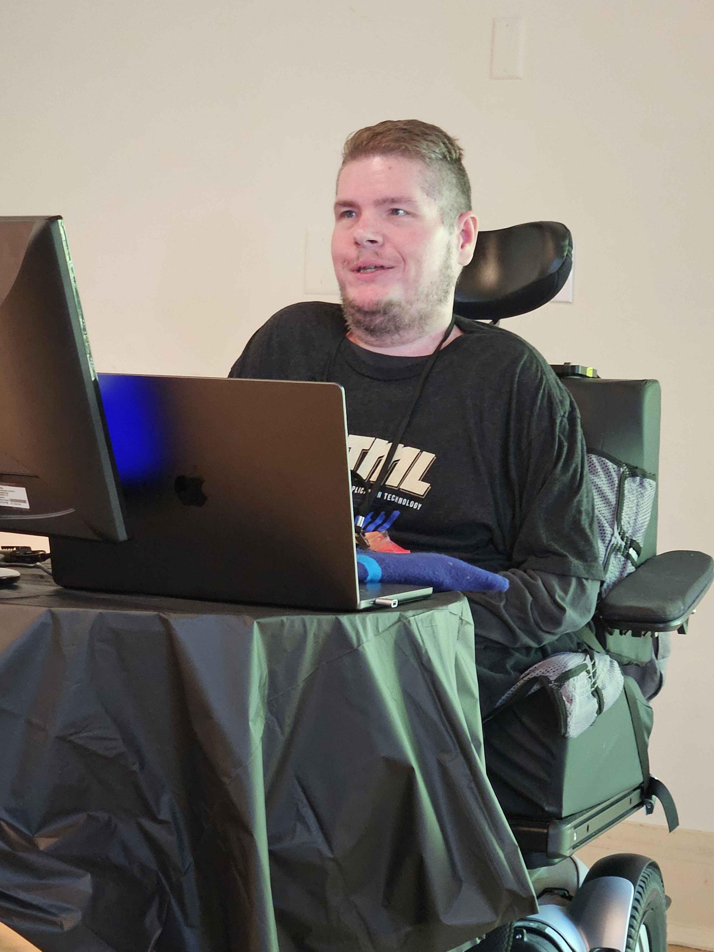 Photo of me at the conference with my laptop giving my talk. I'm
sitting in my wheelchair and rocking my HTML shirt.